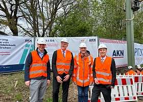 Start der Elektrifizierung: Der erste Oberleitungsmast für die S5 (v. l. Staatssekretär Tobias von der Heide, Geschäftsführer der AKN Eisenbahn GmbH Matthias Meyer,  Björn Schmidt-Dudek von SPITZE SE, Geschäftsführer der NAH Dr. Arne Beck)