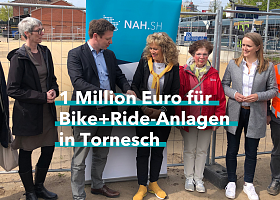 Menschengruppe vor einem Baustelle mit Bauzaun