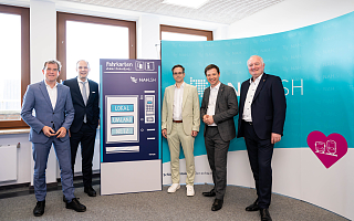 5 Herren (Beck, Kämpfer, Reimers, Von der Heid und Görtz nach dem TEP-Beschluss) stehen nach dem TEP-Beschluss vor einem Dummy eines Fahrkartenautomaten und der NAH.SH-Pressewand