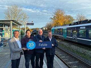 Gratulationen zum 25-jährigen Stationsjubiläum erhalten Feldes Bürgermeister André Buttgereit (2. von links) und Feldes stellvertretender Bürgermeister Eberhard Henning (3. von links) von Jochen Schulz, Bereichsleiter Angebot, NAH.SH (rechts außen) und DB