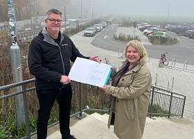 NAH.SH-Sprecher Dennis Fiedel übergibt Bausenatorin Joanna Hagen den Förderbescheid des Landes