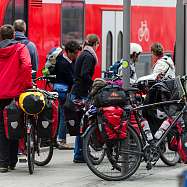 Menschen mit Fahrrädern steigen in einen Zug