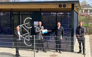 Vier Herren stehen vor einer Bike and Ride-Anlage