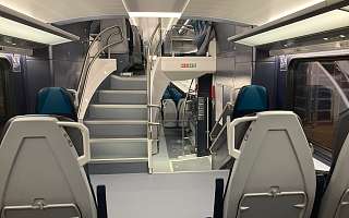 Innenansicht des Zuges. Blick auf die Treppe ins Obergeschoss.