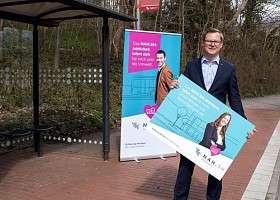 Staatssekretär Dr. Thilo Rohlfs in Bushaltestelle und NAH.SH Aufsteller