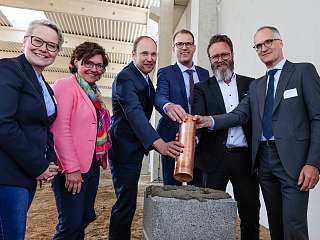 eine Zeitkapsel wird ins Fundament der Akkuzug-Werkstatt eingelassen eine Zeitkapsel wird ins Fundament der Akkuzug-Werkstatt eingelassen