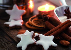 Zimtsterne, Zimtstangen und Teelicht auf einem Tisch 