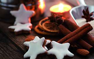 Zimtsterne, Zimtstangen und Teelicht auf einem Tisch 