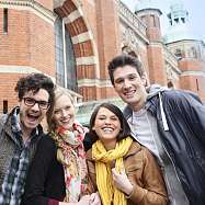 Bild von fünf jungen Menschen vor einem Bahnhofsgebäude