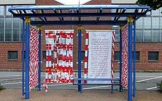 Haltestelle mit rotem Absperrband als Wände