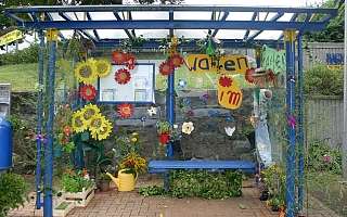 Haltestelle, die mit Blumen aus Papier dekoriert ist