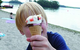 Kind mit Eis in der Hand am Strand