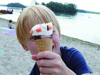 Kind mit Eis in der Hand am Strand