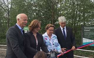 vier Personen schneiden rotes Band durch