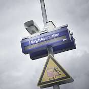 Fahrgastinformationsanzeige und ein Achtung am Bahnsteig Schild