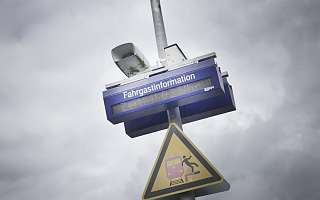 Fahrgastinformationsanzeige und ein Achtung am Bahnsteig Schild