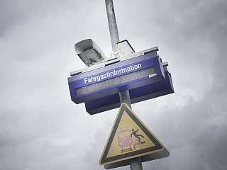 Fahrgastinformationsanzeige und ein Achtung am Bahnsteig Schild