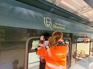 frisch beklebter Zug der nordbahn  mit nordbahn Mitarbeiterin