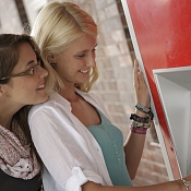 zwei Frauen stehen an einem Fahrkartenautomaten