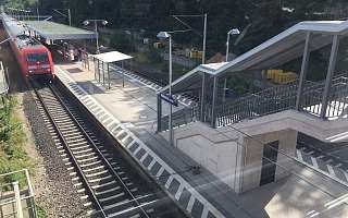 Blick aus der Überführung auf die Gleise mit einfahrendem Zug