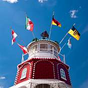 ThinkstockPhotos-545124016.jpg Leuchtturm in rot und weiß, oben mehrere Flaggen