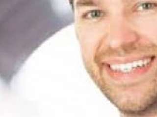 lachender Mann mit rotem Zug in Hintergrund