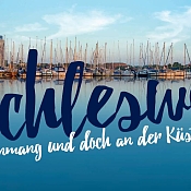 Blick auf Schleswiger Hafen mit dem Schriftzug: Schleswig Mittenmang und doch an der Küste